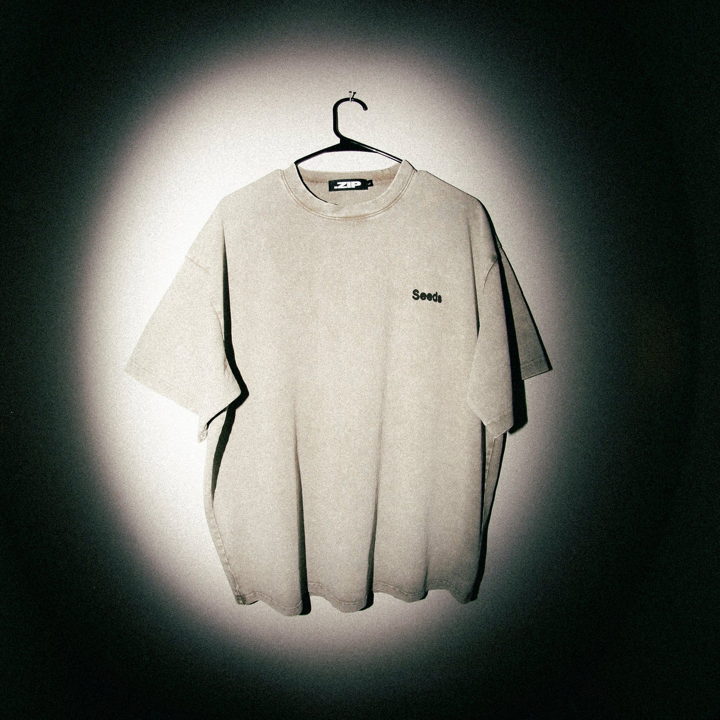 Gray t-shirt with a brand logo on a dark background