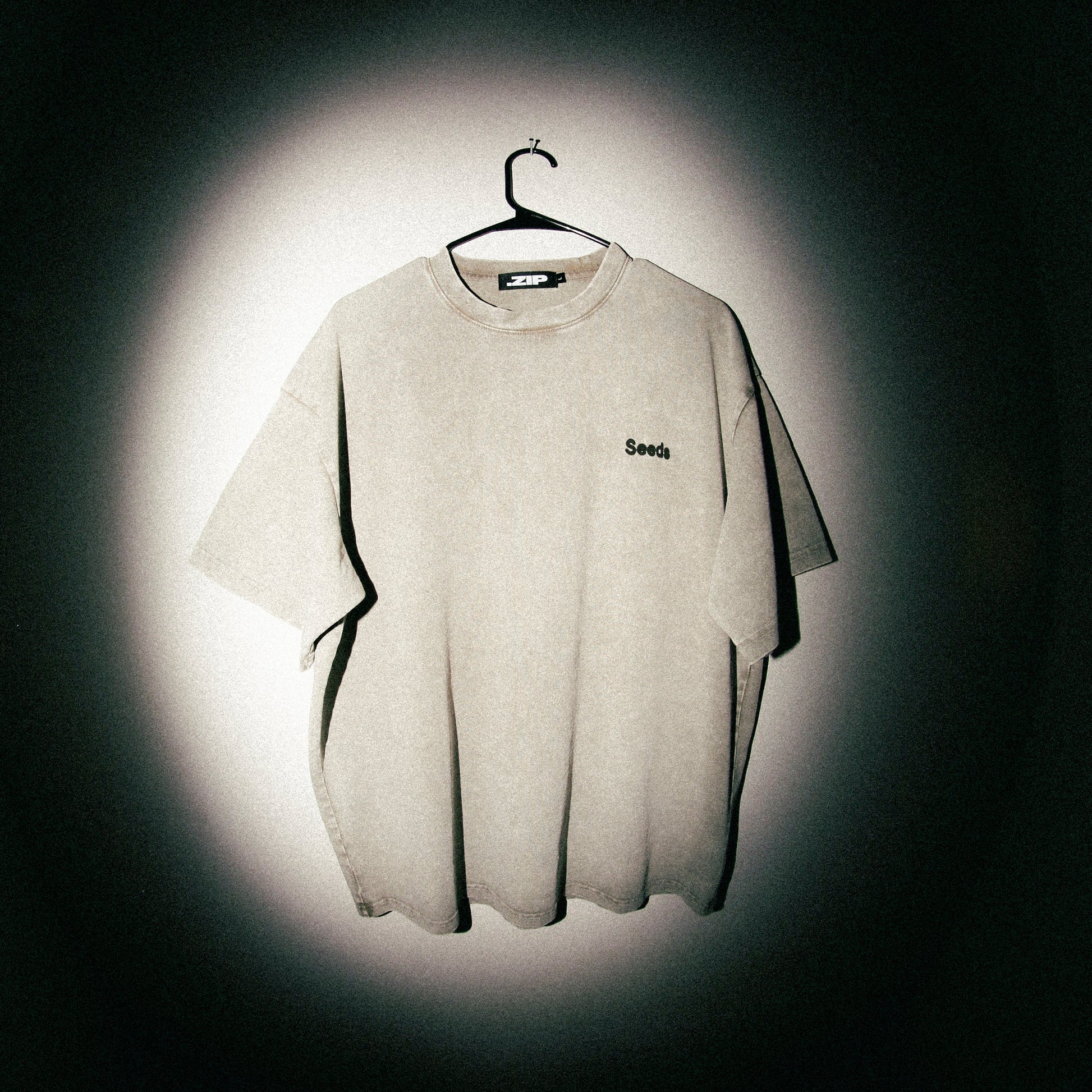 Gray t-shirt with a brand logo on a dark background